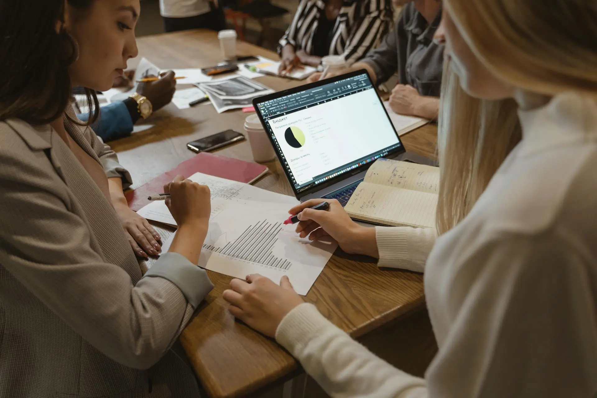 A group of professionals seated at a table with a laptop, collaborating on a business purchase in Chicago.